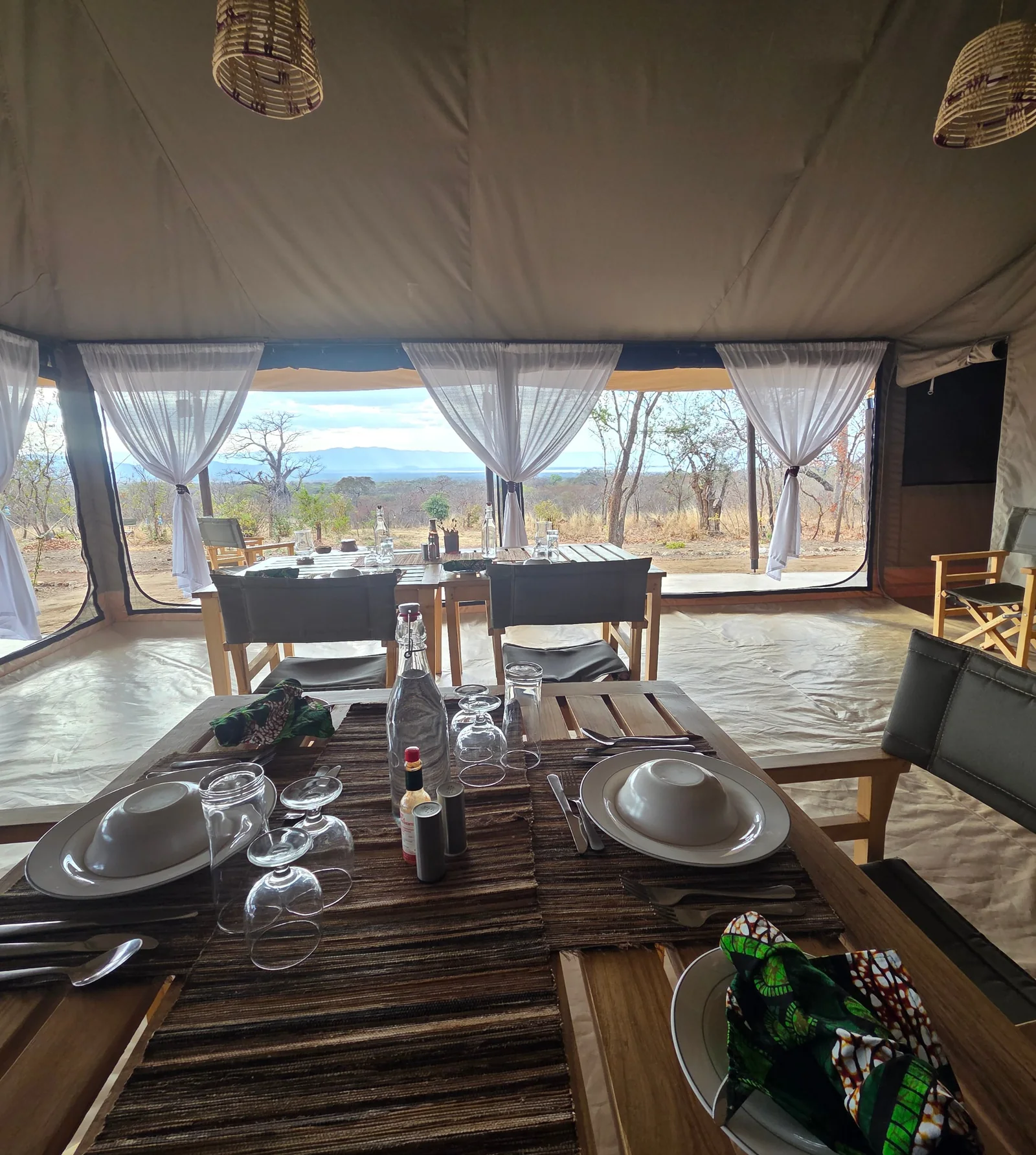 Dining in the mess tent, looking out past the curtains to Lake Burunge and the hills