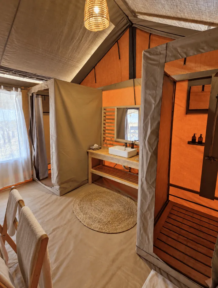En-suite bathroom with wooden vanity, washbasin, bucket shower cubicle and toilet cubicle